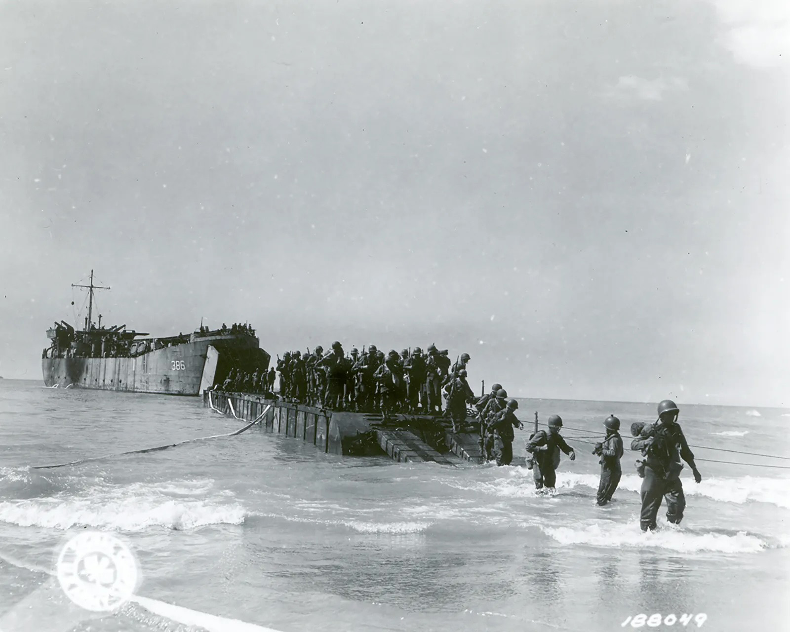 Allied troops disembarking onto a beach near Licata, Sicily, from a barge after being ferried from an outlying LST (landing ship, tank), July 10, 1943. (U.S. Signal Corps/National Archives, Washington, DC)